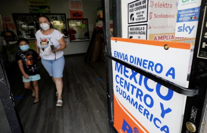 Una mujer sale de una tienda que ofrece servicios para enviar remesas a México y Centroamérica, en San Diego (EE UU). GREGORY BULL (AP)
