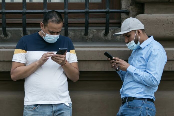Dos hombres utilizan sus teléfonos móviles en el centro de Ciudad de México. GALO CAÑAS (CUARTOSCURO)