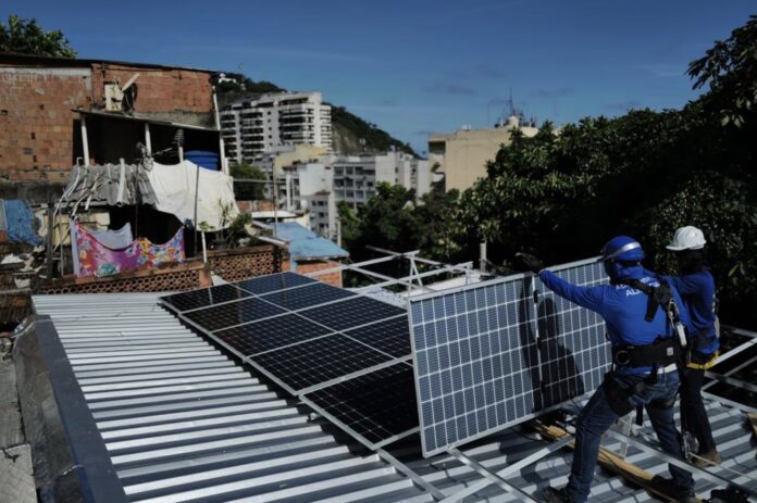 Trabajadores de la organización sin fines de lucro Revolusolar instalan paneles solares en una favela en Río de Janeiro (Brasil), el pasado 1 de marzo. LUCAS LANDAU (BLOOMBERG)