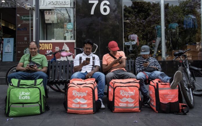 Repartidores de comida rápida por aplicaciones de celular, esperan pedidos, en Ciudad de México, el 28 de marzo 2020. MARIO JASSO (CUARTOSCURO)
