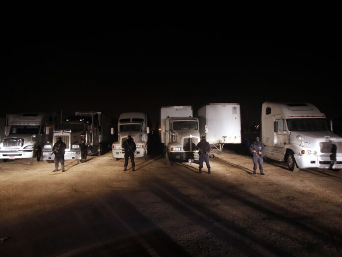 Policías frente a camiones de carga robados, a las afueras de Tijuana (Baja California), en una imagen de archivo. GUILLERMO ARIAS (AP)