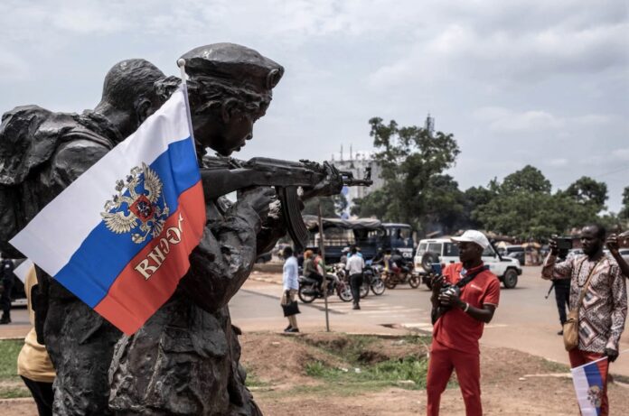 Una bandera con el emblema de Rusia cuelga de un monumento de instructores rusos en Bangui durante una marcha en apoyo a la presencia de Rusia y China en la República Centroafricana el 22 de marzo. BARBARA DEBOUT/AFP VÍA GETTY IMAGES