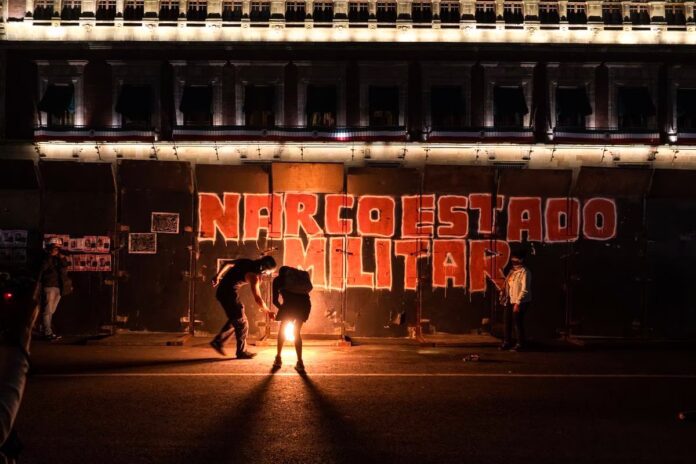 Una pinta en las vallas que protegían el Palacio Nacional durante la marcha por el noveno aniversario del Caso Ayotzinapa, en septiembre de 2023. HECTOR GUERRERO
