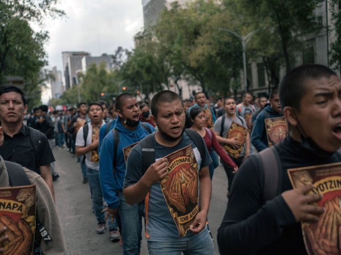 Familiares y compañeros de clase de los 43 normalistas de Ayotzinapa durante una marcha en CDMX en 2023 (AP)