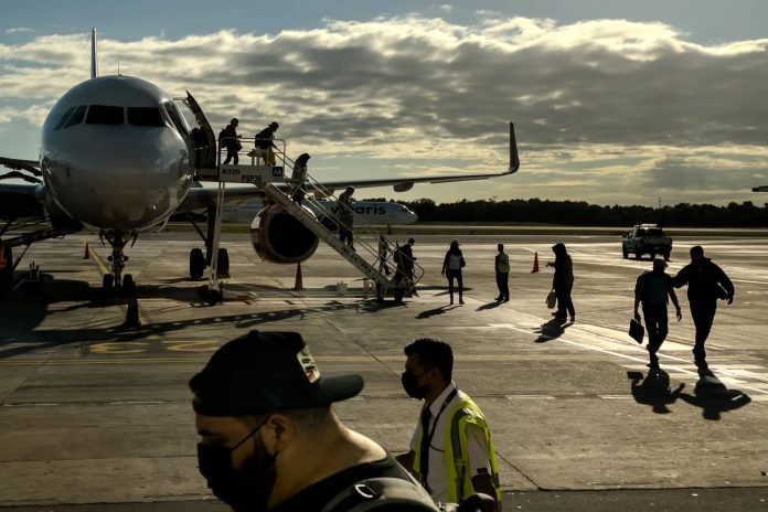 Un grupo de pasajeros desembarca de un avión en el Aeropuerto Internacional de Cancún (CUN) en Cancún, Quintana Roo - César Rodríguez/Bloomberg