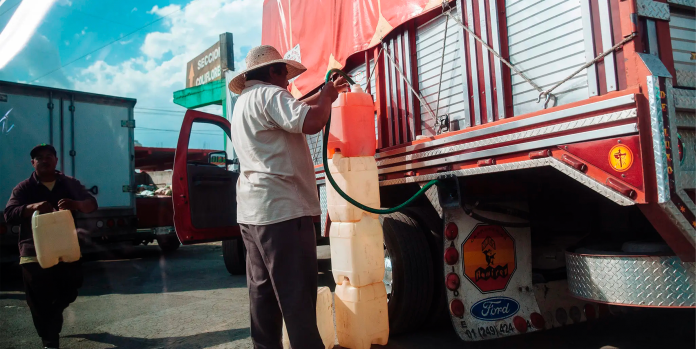 Un hombre llena el tanque de un camión con gasolina robada - Rodrigo Cruz